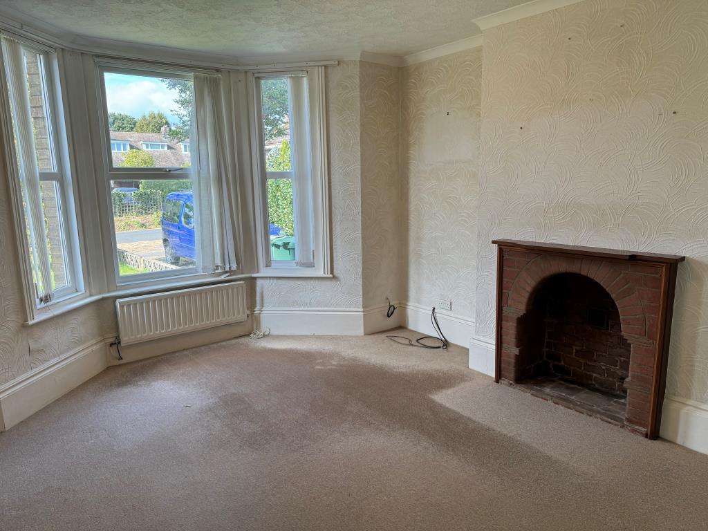 Lot: 154 - THREE-BEDROOM GROUND FLOOR APARTMENT FOR IMPROVEMENT WITH GARDENS AND GARAGE - Room with fireplace and window to front garden